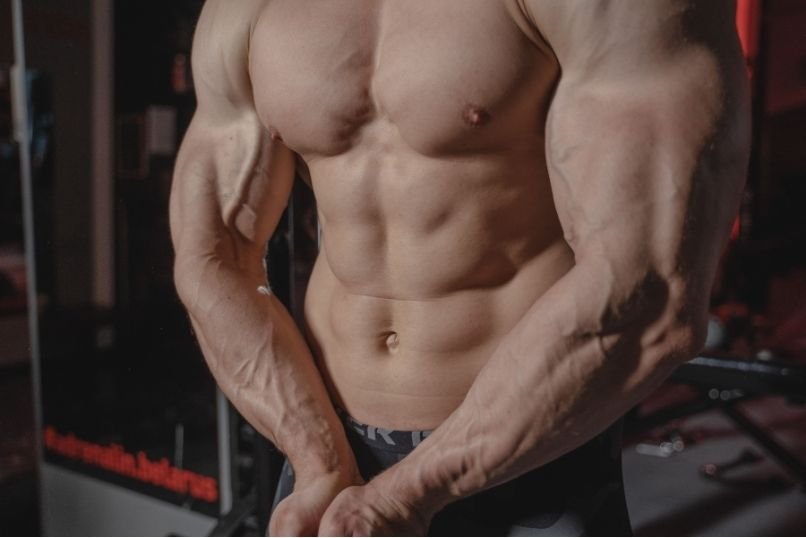Bodybuilder flexing lean muscle mass to illustrate the physical effects discussed when asking what is Masteron