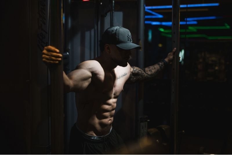 Muscular athlete resting between sets for basic muscle hypertrophy