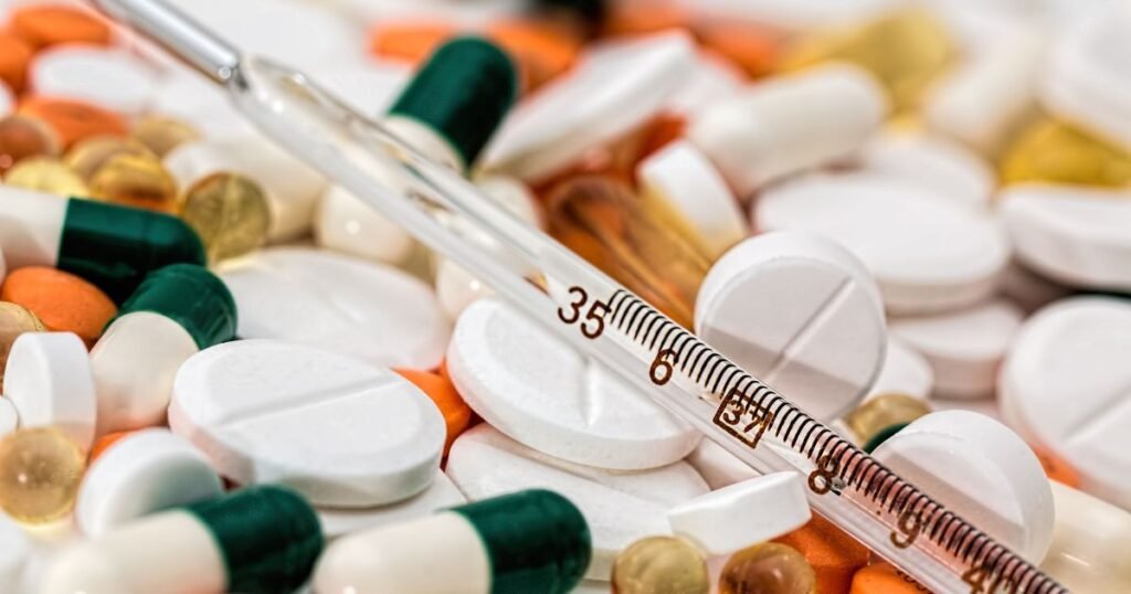 Medical thermometer over pills representing the pharmacore product list New York City