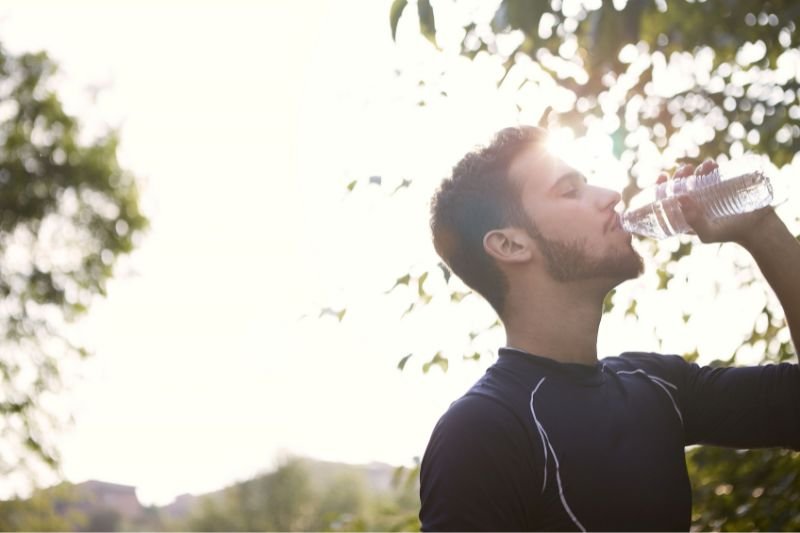 Athlete drinking water outdoors during the peak week water loading phase
